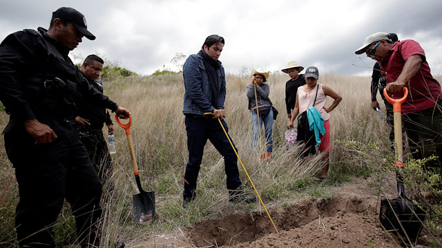 File photo: A forensic anthropologist (C) and relatives of missing persons take part in a search for mass graves at a cemetery in the town of Ahuihuiyuco, in the state of Guerrero, Mexico May 10, 2018