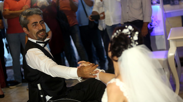 على كرسي متحرك.. تركي يرقص مع عروسته في حفل زفافهما

