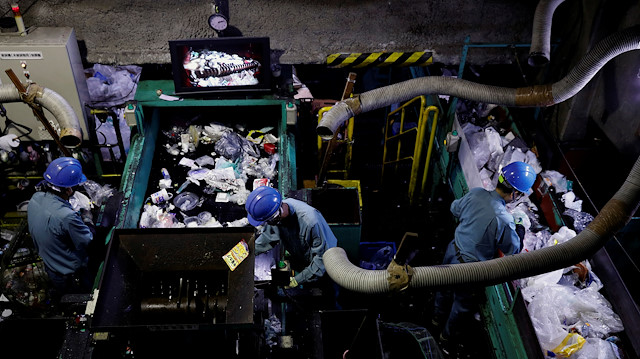 Workers sort out plastic waste for recycling at Minato Resource Recycle Center in Tokyo, Japan 