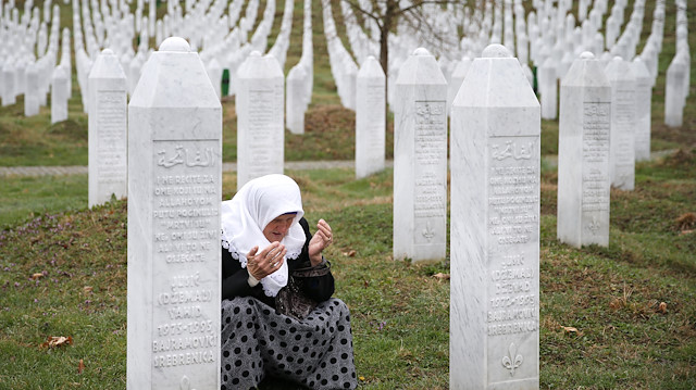 A woman prays near a grave of her family members in the Memorial centre Potocari before the judges verdict on former Bosnian Serb political leader Radovan Karadzic's appeal of his 40 year sentence for war crimes, near Srebrenica, Bosnia and Herzegovina March 20, 2019. REUTERS/Dado Ruvic


