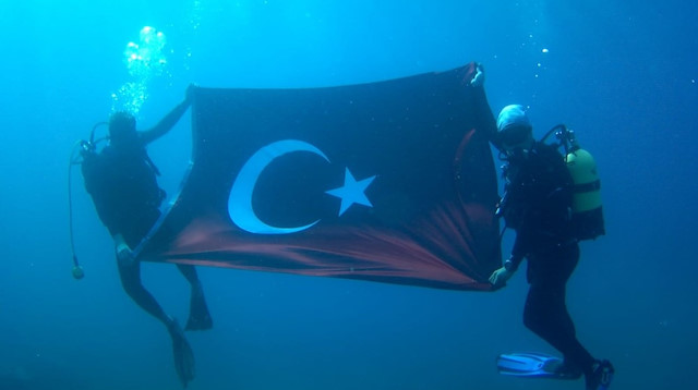 dalış ekibi, su altında Türk bayrağı açıp, saygı duruşunda bulunarak şehit ve gazileri selamladı.