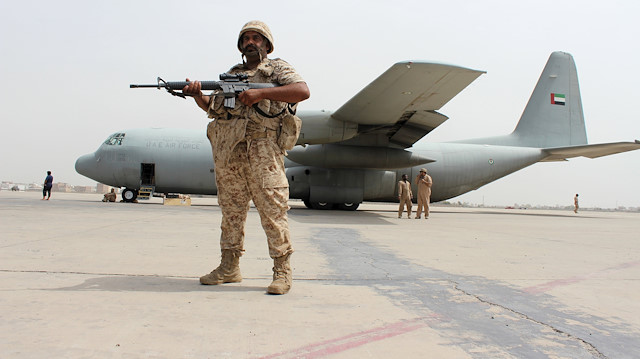A soldier from the United Arab Emirates stands guard next to a UAE military plane at the airport 