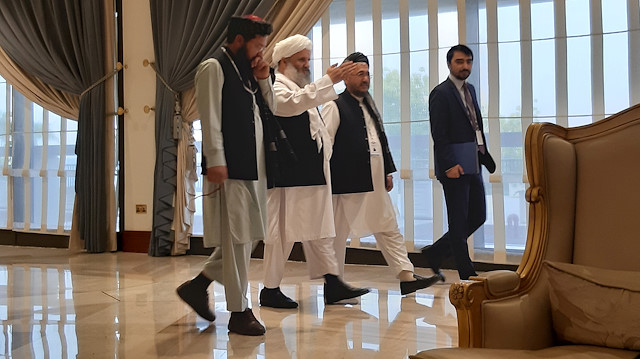 Members of Afghan delegations walk during the second day of Intra-Afghan conference