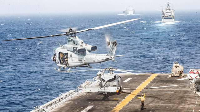  A U.S. Marines UH-1Y Venom helicopter takes off from the flight deck of the U.S. Navy amphibious assault ship USS Boxer, near a Light Marine Air Defense Integrated System (LMADIS) counter-unmanned aircraft system mounted on a vehicle parked at the bow, during its transit through Strait of Hormuz in Gulf of Oman, Arabian Sea, July 18, 2019. Picture taken July 18, 2019. 

