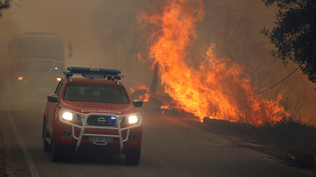 Firefighters drive through smoke from a forest fire in Chaveira, Portugal July 22, 2019