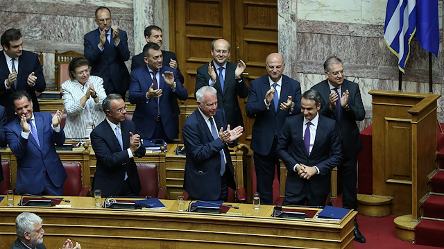 Greek Prime Minister Kyriakos Mitsotakis acknowledges applause from ministers of his government following a confidence vote on government policies in Athens, Greece