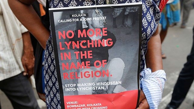 A woman holds a placard during a protest against the lynching of a Muslim man Tabrez Ansari 