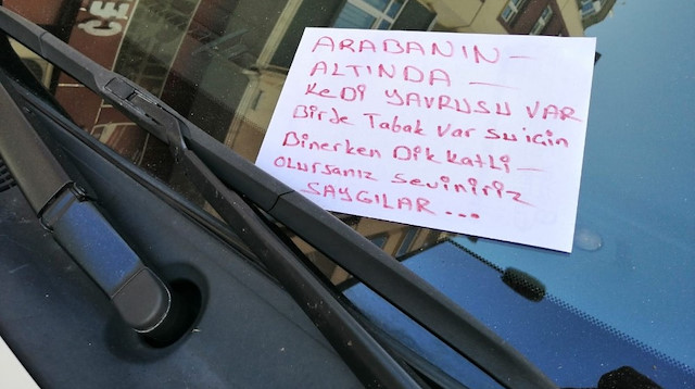 Yoldan geçen bir vatandaş arabanın altında kalan kedi için sürücüye yazdığı uyarı notu.