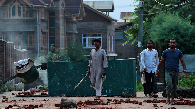 Kashmiris walk past a blockade put up by residents to prevent security personnel from sealing a mosque ground ahead of the Eid-al-Adha prayers during restrictions after the scrapping of the special constitutional status for Kashmir by the Indian government, in Srinagar, August 12, 2019. REUTERS/Danish Siddiqui

