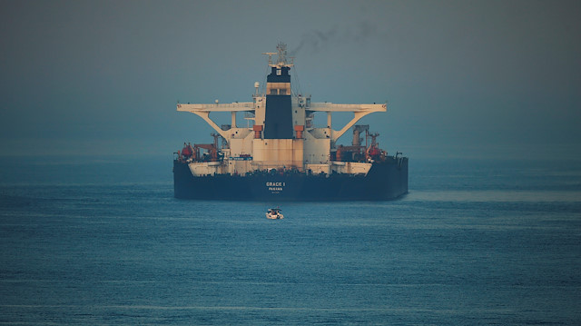 A small boat sails past Iranian oil tanker Grace 1 as it sits anchored 