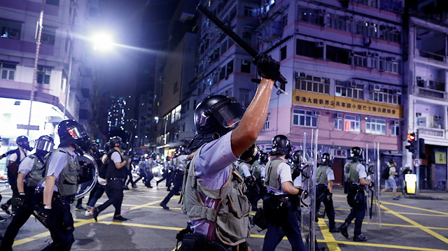 : Police advance through the Sham Shui Po neighbourhood during clashes 
