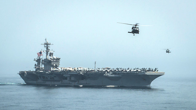 Helicopters fly from the aircraft carrier USS Theodore Roosevelt 