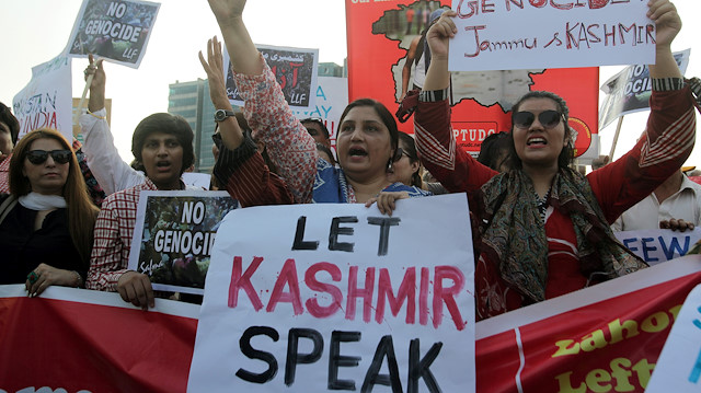 People carry signs as they chant slogans to express solidarity with the people of Kashmir, during a rally in Lahore, Pakistan, August 20, 2019. REUTERS/Mohsin Raza

