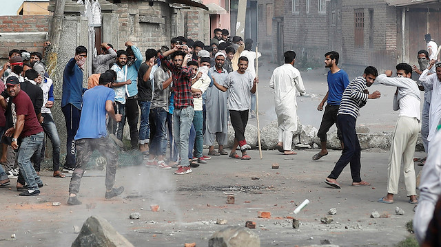 File photo: Kashmiris run for cover as a teargas shell fired by Indian security forces 