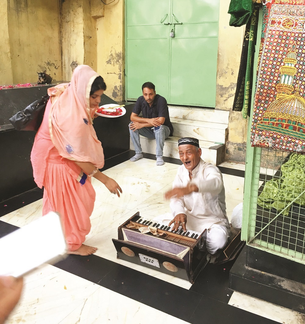 Delhi’de Nizameddin Evliya türbesinin avlusunda birçok kişi sufi müziği “kavvali” icra ediyor.