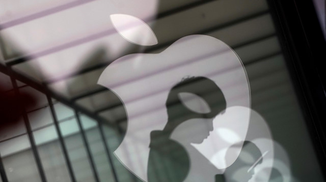 File photo: Apple company logos are reflected on the glass window outside an Apple store 
