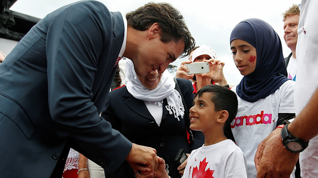 Canada's Prime Minister Justin Trudeau shakes hands with a Syrian refugee