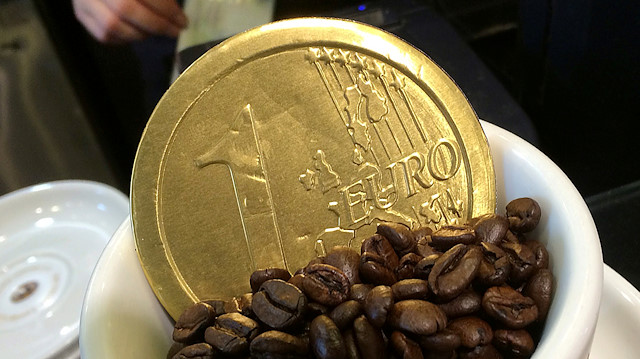 FILE PHOTO: An employee uses a cash till, behind a chocolate shaped one Euro coin in a coffee cup, at a cafe in London, Britain, October 15, 2014. REUTERS/Toby Melville/File Photo

