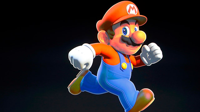 Nintendo Creative Fellow Shigeru Miyamoto stands next to the Super Mario character 