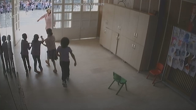 Sultangazi'deki okulda tahliye sırasında 2 öğrenci yürüme engeli bulunan arkadaşının koluna girerek dışarı çıkartırken.