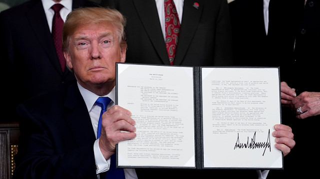 FILE PHOTO: U.S. President Donald Trump holds his signed memorandum on intellectual property tariffs on high-tech goods from China, at the White House in Washington, U.S. March 22, 2018. REUTERS/Jonathan Ernst/File Photo


