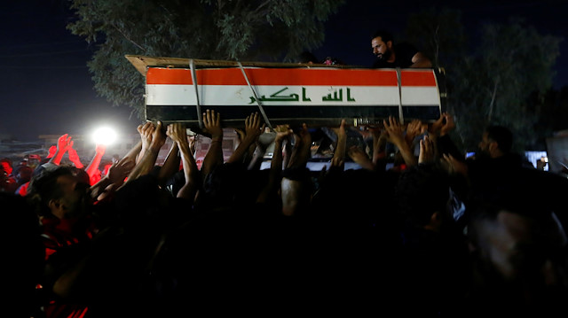 Men carry the coffin of a demonstrator who was killed during anti-government protests in Iraq
