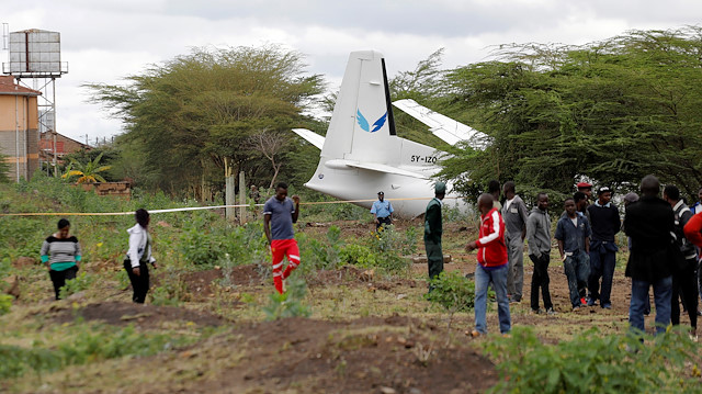 Bystanders watch the Fokker 50, 5Y-IZO plane operated by Silverstone Air that crash landed after take-off from the Wilson Airport in Nairobi, Kenya