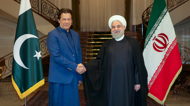 Iranian President Hassan Rouhani shakes hands with Pakistani Prime Minister Imran Khan in Tehran, Iran, October 13, 2019