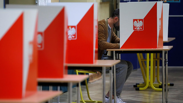 A man attends a voting during parliamentary election at a polling station in Warsaw