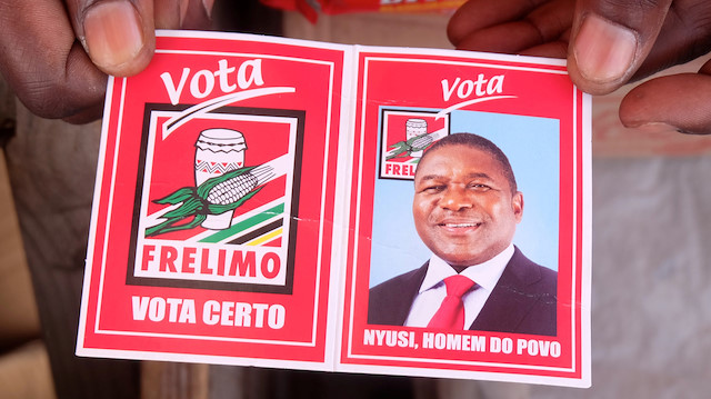 A local holds a card with a picture of Mozambique's president and leader of the Frelimo Party, Filipe Nyusi, ahead of Tuesday's provincial and legislative elections, in Maputo, Mozambique, October 11, 2019 REUTERS/Grant Lee Neuenburg

