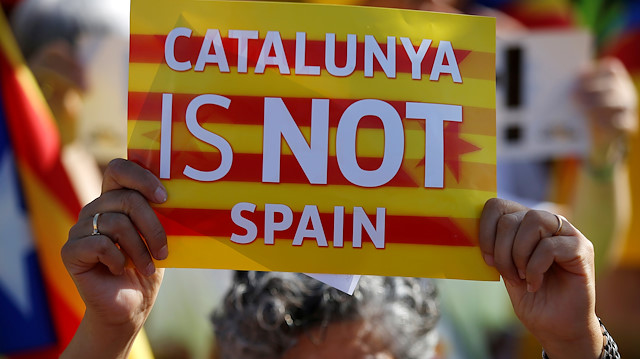 A protester holds a poster with the slogan "Catalunya is not Spain"