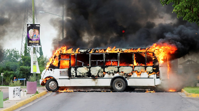 A burning bus, set alight by cartel gunmen to block a road, is pictured during clashes with federal forces following the detention of Ovidio Guzman, son of drug kingpin Joaquin "El Chapo" Guzman, in Culiacan, Sinaloa state, Mexico
