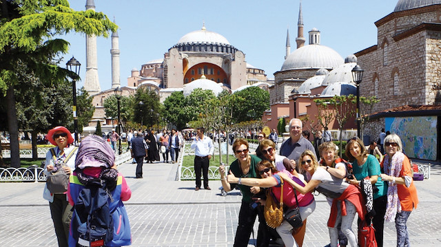 Ayasofya ile fotoğraf çekilen turistler.