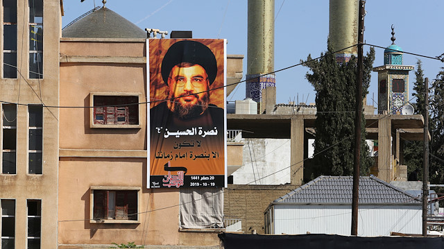 A banner depicting Lebanon's Hezbollah leader Sayyed Hassan Nasrallah is hung as his supporters listen to his televised speech in Baalbeck, Lebanon