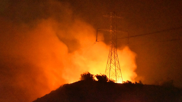 File photo :A wind-driven wildfire burns near power lines in Sylmar, California