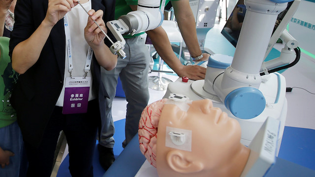 A staff member performs a robot surgery at Tinavi's booth at the World Robot Conference (WRC) 