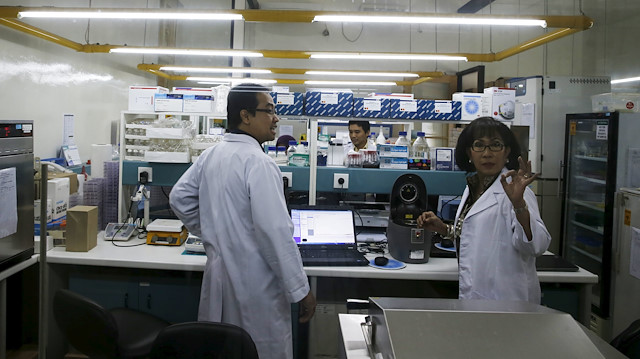 Herawati Sudoyo (R), deputy director of the government-funded Eijkman Institute, talks to her colleague at a dengue laboratory at Eijkman Institute in Jakarta.