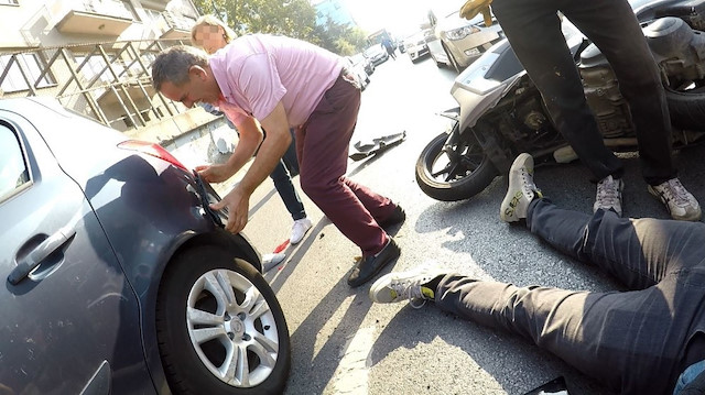 Kazanın ardından aracından inen kadın, yerde yatan yaralı sürücüyle ilgilenmek yerine otomobilinin arkasına baktı.