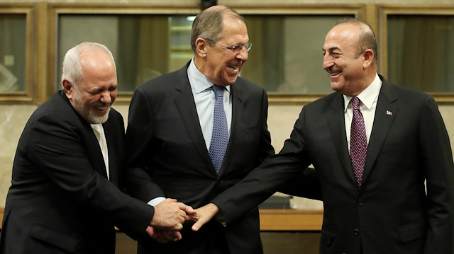 Russian Foreign Minister Sergei Lavrov, Turkish Foreign Minister Mevlut Cavusoglu and Iranian Foreign Minister Mohammad Javad Zarif shake hands as they attend a news conference after talks on forming a constitutional committee in Syria, at the United Nations in Geneva, Switzerland, December 18, 2018. REUTERS/Denis Balibouse  