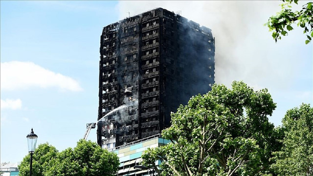 Smoke rises from the building after a huge fire engulfed the 24 storey residential Grenfell Tower block in Latimer Road, West London in the early hours of this morning on June 14, 2017 in London, England.