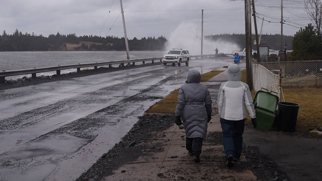 File photo: Pedestrians walk along a closed section of road as storm surge from the Atlantic Ocean causes waves to crash over the break wall during Storm Grayson in Halifax, Nova Scotia, Canada January 5, 2018