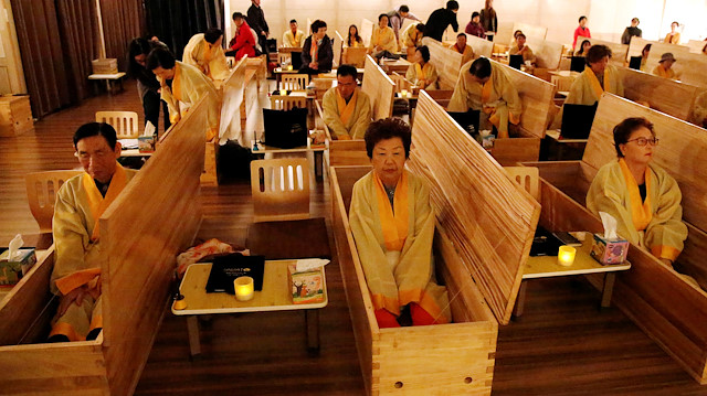 Participants sit inside coffins during a "living funeral" event as part of a "dying well" programme, in Seoul, South Korea, October 31, 2019. Picture taken on October 31, 2019. REUTERS/Heo Ran

