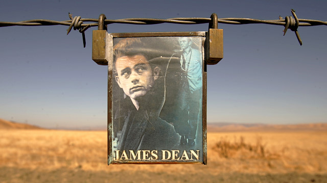FILE PHOTO: A portrait of U.S. actor James Dean hangs from a fence near the intersection of Highways 46 and 41 near Cholame, California September 30, 2005./File Photo

