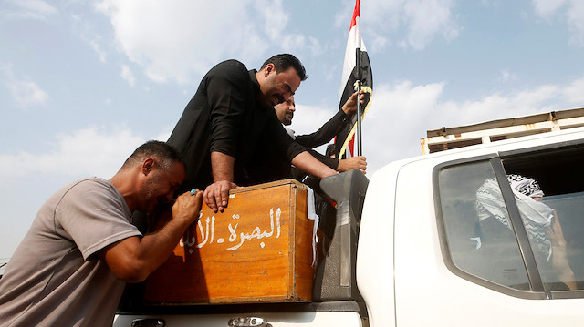 Iraklı bir adam Basra'da gerçekleşen bir cenaze töreni sırasında hükümet karşıtı protestolarda öldürülen bir göstericinin tabutunda yas tutuyor. 