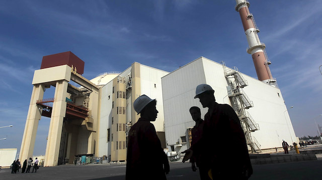Iranian workers stand in front of the Bushehr nuclear power plant, about 1,200 km (746 miles) 