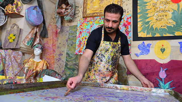 فنان تركي يبدع في تزيين الملابس باستخدام فن "الإيبرو"