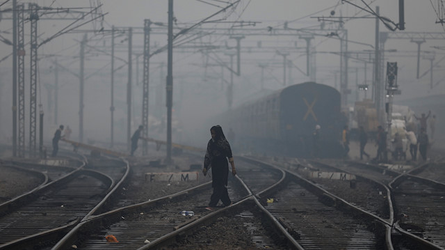 A woman crosses a railway line on a smoggy morning in New Delhi, India, November 15, 2019. 