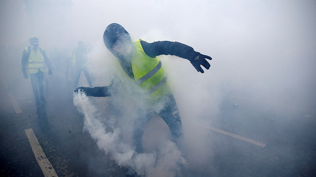FILE PHOTO: Tear gas fills the air as a protester wearing a yellow vest, a symbol of a French drivers' protest against higher diesel taxes, demonstrates near the Place de l'Etoile in Paris, France, December 1, 2018. 