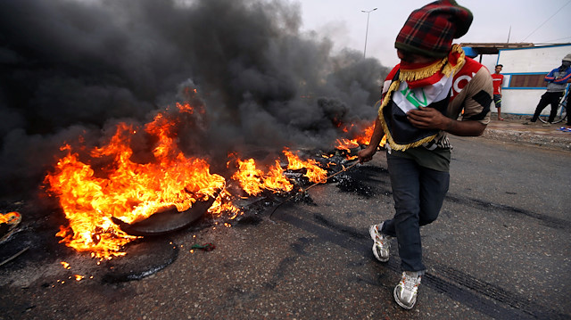 Iraklı protestocular, Basra'da devam eden hükümet karşıtı protestolar sırasında lastik yakıyor. 