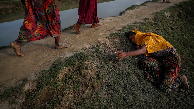 FILE PHOTO: An exhausted Rohingya refugee fleeing violence in Myanmar cries for help from others crossing into Palang Khali, near Cox's Bazar, Bangladesh November 2, 2017. REUTERS/Hannah McKay/File Photo

